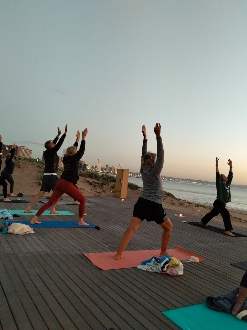 Yoga on the deck at sunrise, ocean behind
